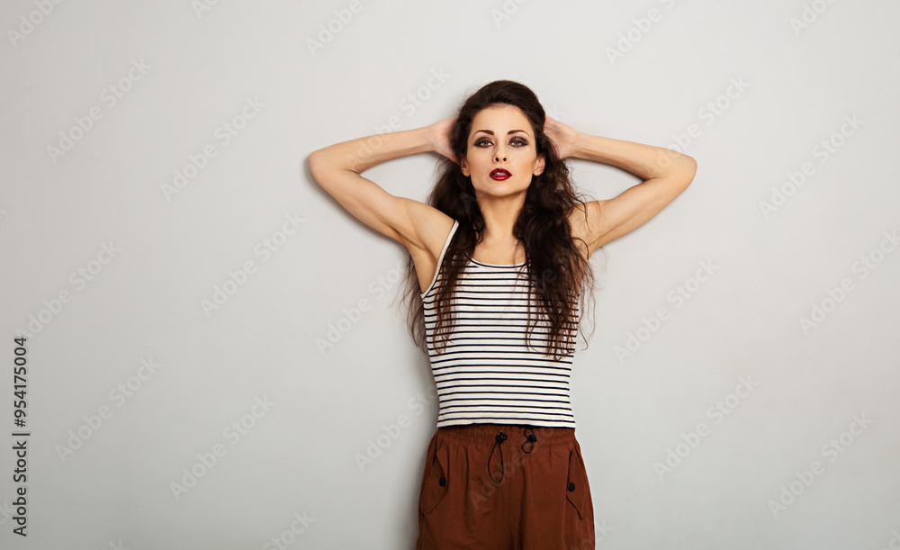 Sexy beautiful make-up woman with red lipstick and smoky shadow eyes looking in stripped casual top and cotton red yellow trousers on white empty copy space background. Portrait Sexy beautiful make-up woman with red lipstick and smoky shadow eyes looking in stripped casual top and cotton red yellow trousers on white empty copy space background. Portrait