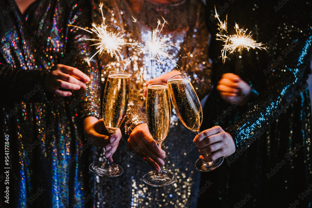 Friends celebrating Christmas or New Year eve party with Bengal lights and champagne.