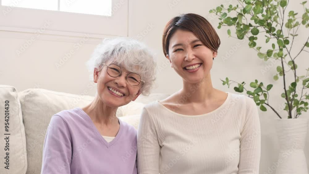 母親と娘の笑顔のポートレート リビングルーム カメラ目線 母親と娘の笑顔のポートレート リビングルーム カメラ目線