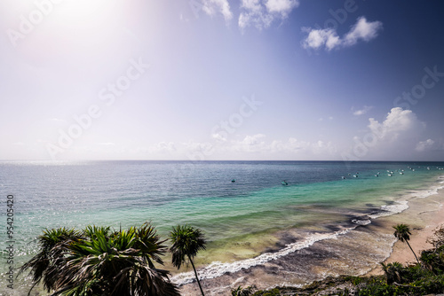 Tulum Ruins and Palm Tree, Tulum beach, Mayan ruins of Tulum at tropical coast. God of Winds Temple at paradise beach. Mayan ruins of Tulum, Quintana Roo, Mexico.