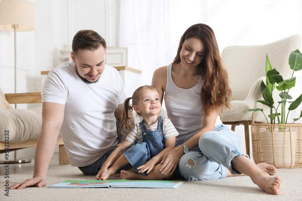 Happy family. Parents and their cute little daughter with book at home Happy family. Parents and their cute little daughter with book at home
