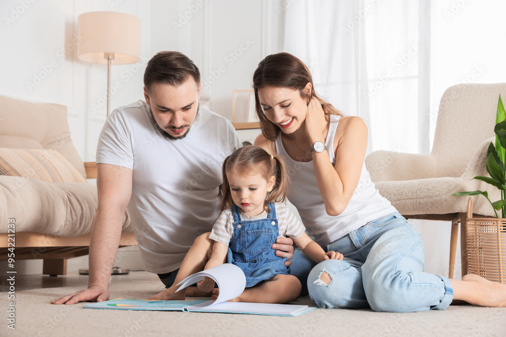 Happy family. Parents and their cute little daughter reading book at home Happy family. Parents and their cute little daughter reading book at home