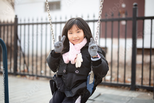 Cute little girl playing on a swing