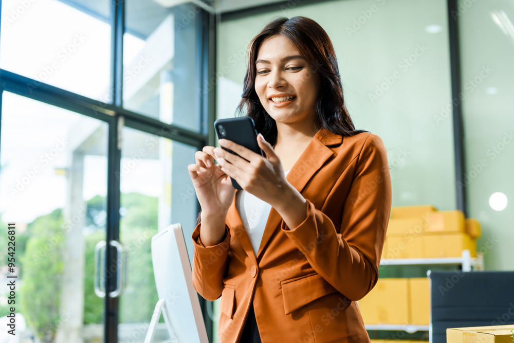 Fototapeta premium successful Asian businesswoman happily celebrates her achievements during Pride Month, overcoming office syndrome and receiving congratulations for thriving LGBTQ-owned shipping and retail business.
