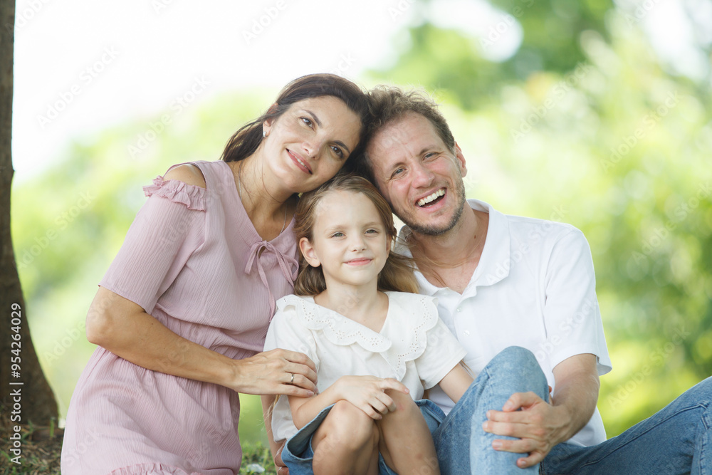 Happy family relaxing together at the park, caucasian family with father, mother, and children walking at the park. Happy family relaxing together at the park, caucasian family with father, mother, and children walking at the park.