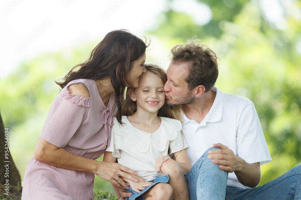 Happy family relaxing together at the park, caucasian family with father, mother, and children walking at the park. Happy family relaxing together at the park, caucasian family with father, mother, and children walking at the park.