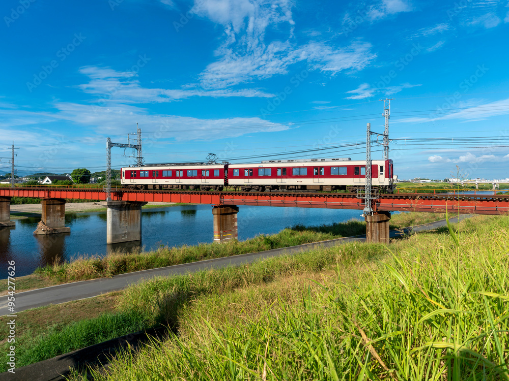 真夏の大和川を渡る近鉄道明寺線の電車