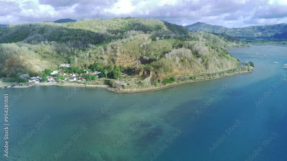 Aerial view of a scenic road near Sekotong, Lombok, Indonesia, featuring lush greenery, a winding road, and a dramatic cliff face. Aerial view of a scenic road near Sekotong, Lombok, Indonesia, featuring lush greenery, a winding road, and a dramatic cliff face.