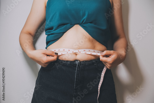 fat woman, fat belly, chubby, obese woman hand holding excessive belly fat with measure tape, woman diet lifestyle concept