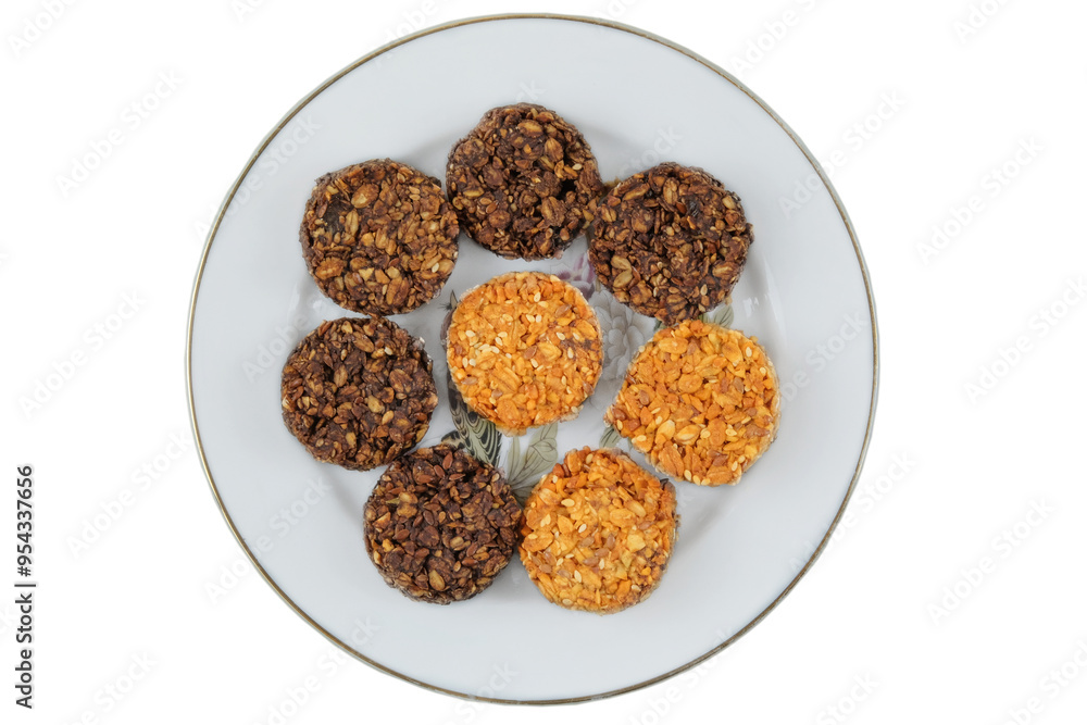 Variety of cakes in ceramic plate isolated on a white background. Yellow and brown romantic biscuit. Top view. Variety of cakes in ceramic plate isolated on a white background. Yellow and brown romantic biscuit. Top view.