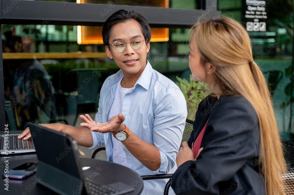 A smart Asian businessman is having an informal meeting with his colleague at a coffee shop. A smart Asian businessman is having an informal meeting with his colleague at a coffee shop.