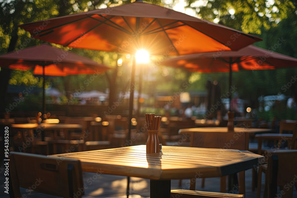 Fototapeta premium Cafe umbrellas, tables, and chairs bathed in sunlight