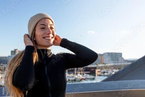 Happy and smiling young caucasian fit woman wearing sports clothing outdoors in winter time. Copy space. photo