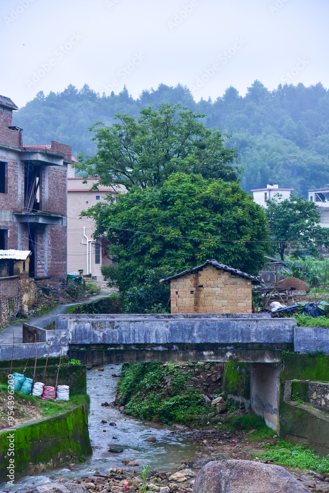 Fototapeta premium Mud houses and stream in rural. Rural scenery of Yangfu Village, Xinfeng County, Shaoguan.