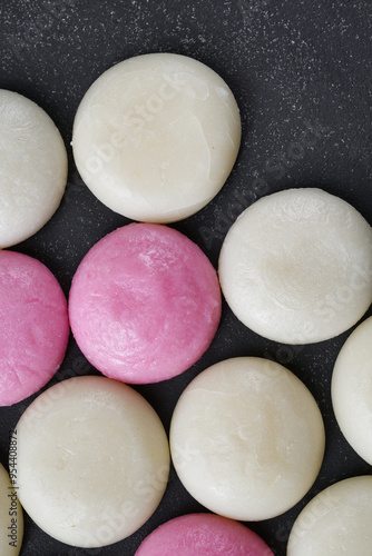 日本のお正月：紅白丸餅　黒背景　コピースペースあり 背景素材  Japanese New Year: Red and white round rice cakes (Marumochi)  on a black background with copy space,background material photo