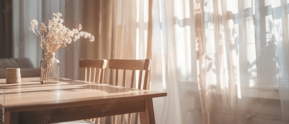 A serene dining space featuring a wooden table, chairs, and a vase of flowers illuminated by soft, natural light from the curtains. A serene dining space featuring a wooden table, chairs, and a vase of flowers illuminated by soft, natural light from the curtains.
