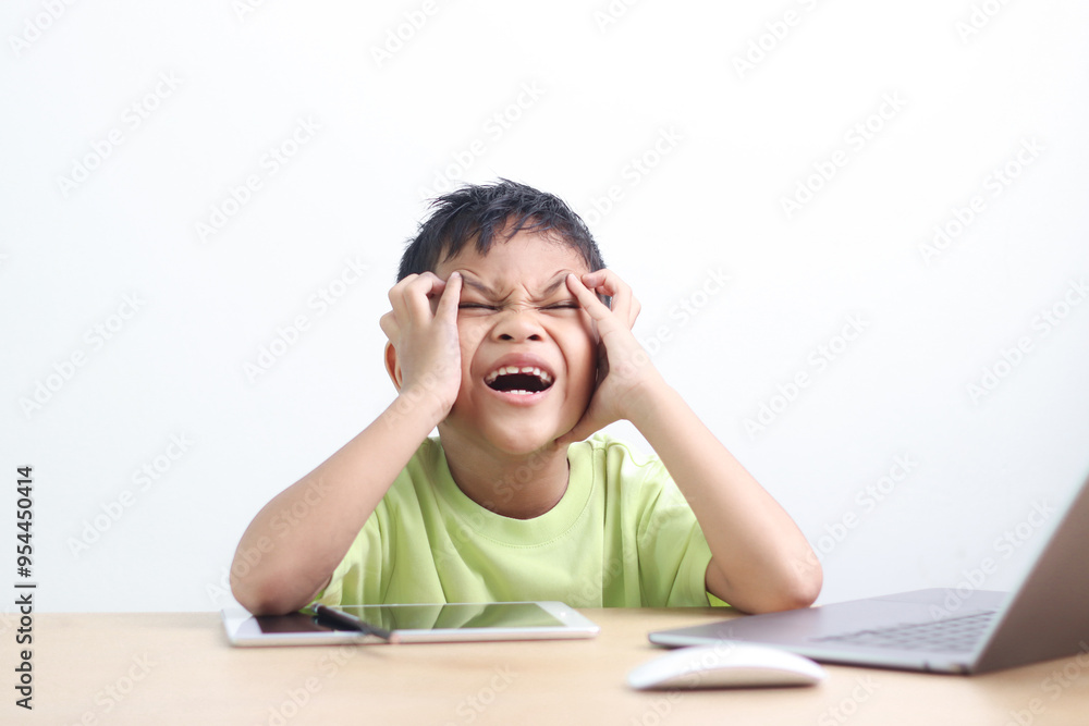 A little asian boy studying online learning class with online video call zoom teacher at home. E-learning or Home schooling education concept. A little asian boy studying online learning class with online video call zoom teacher at home. E-learning or Home schooling education concept.