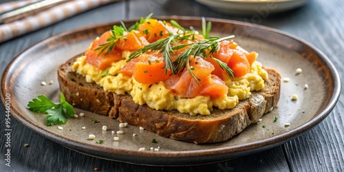 Wholemeal bread, perfectly toasted and topped with scrambled eggs and smoked salmon, on a minimalist plate