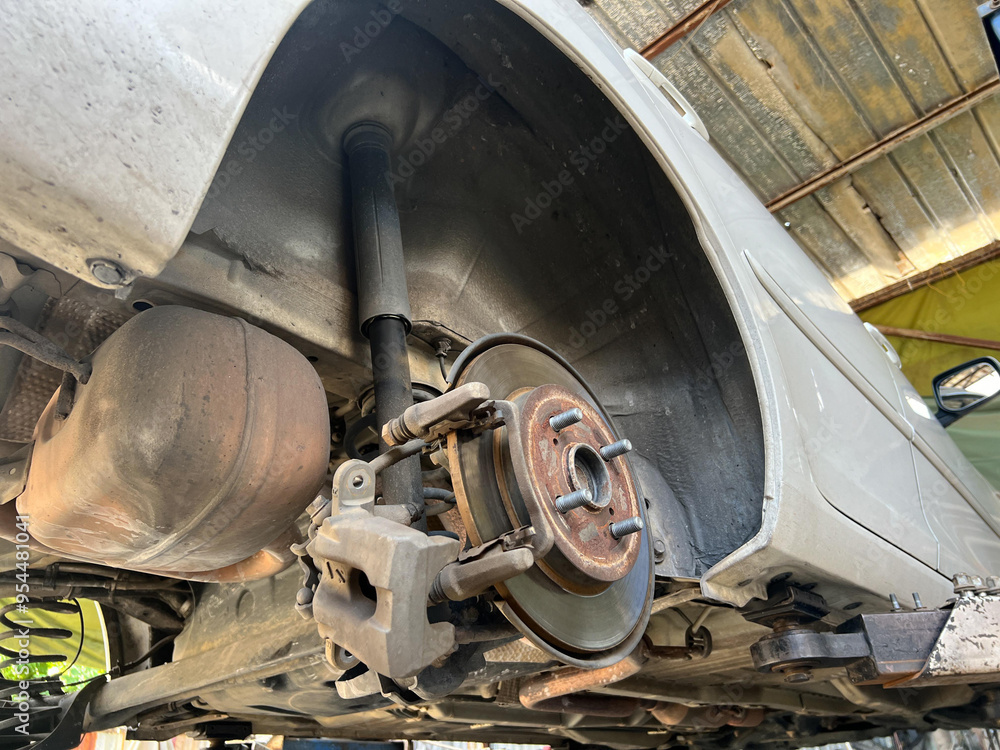 custom made wallpaper toronto digitalUnderneath view of cars suspension and brake system, showcasing brake caliper and rotor. image captures mechanical details of automotive engineering.