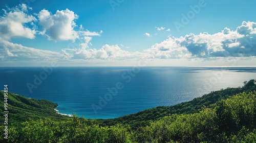 Coastal hillside overlooking the vast blue ocean, with the sky filled with soft clouds and plenty of copy space.