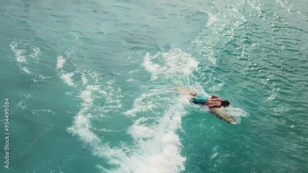 Aerial view of person surfing, catchign a wave in Cozumel Island, Mexican Caribbean,Mexico Aerial view of person surfing, catchign a wave in Cozumel Island, Mexican Caribbean,Mexico