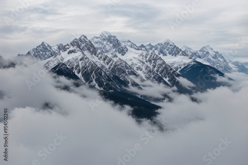 Snow-capped peaks of majestic mountains rising above swirling clouds in tranquil nature