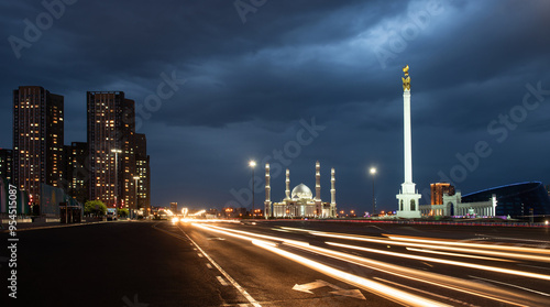 Kazakhstan Independence Monument with the magical bird Samruk on top and the Khazret-Sultan Mosque in Astana on a summer evening