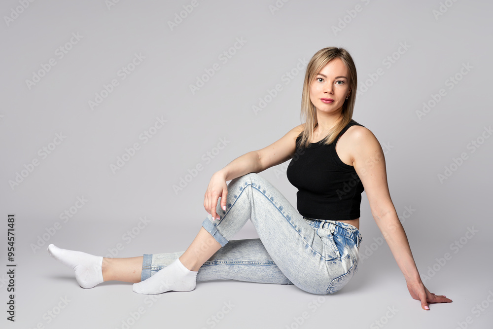 Fototapeta premium Portrait of a young woman on white background. Beautiful blonde woman wearing casual clothing, smiling and looking at camera