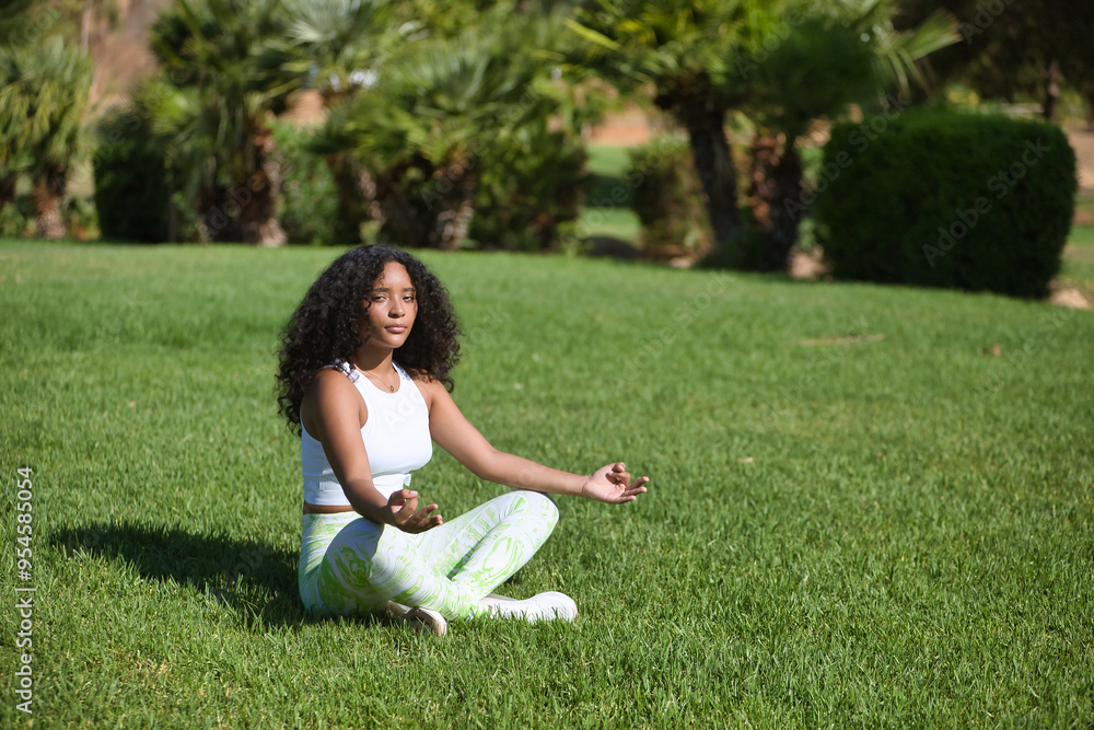 Young, beautiful, brunette, Latina woman with curly hair and sportswear, performing yoga exercises in an outdoor park. Concept sport, relaxation, meditation, exercise. Young, beautiful, brunette, Latina woman with curly hair and sportswear, performing yoga exercises in an outdoor park. Concept sport, relaxation, meditation, exercise.