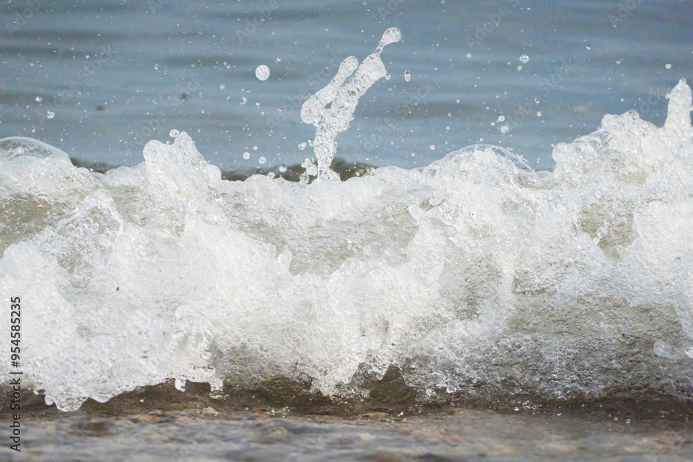 White foam and sea water drop splashes slow motion with sand and blue water White foam and sea water drop splashes slow motion with sand and blue water