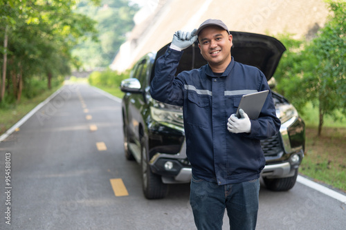Asian male professional auto mechanic doing onsite service checking broken engine. Inspect the damage according to the list to replace parts and maintain the car on-site. emergency assistance service