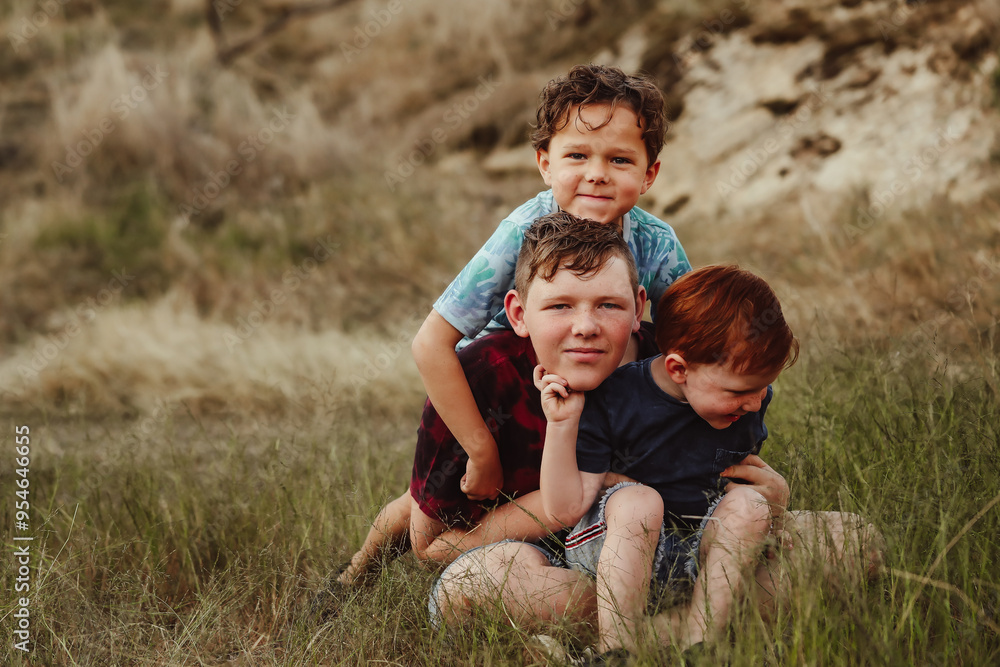 Three brothers sitting together on a rock in the Australian bush Three brothers sitting together on a rock in the Australian bush