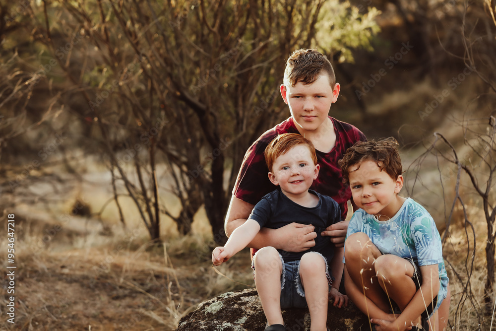 Three brothers sitting together on a rock in the Australian bush Three brothers sitting together on a rock in the Australian bush