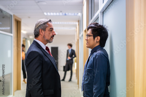 Caucasian businessman working with Asian team in the office workplace.