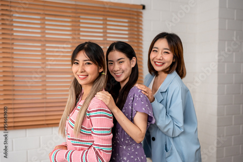 Portrait group of women friends standing together in living room at home. 