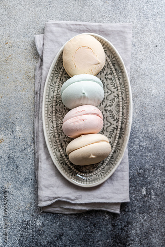 Delicate macarons in soft pastel hues on a vintage plate photo