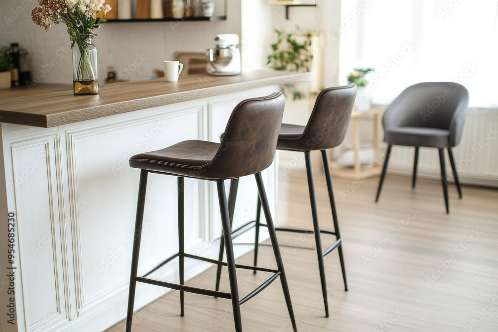 Pair of swivel bar stools with cream leatherette and dark wood frame, placed on an area rug in a modern kitchen with white cabinets and marble countertop. Pair of swivel bar stools with cream leatherette and dark wood frame, placed on an area rug in a modern kitchen with white cabinets and marble countertop.