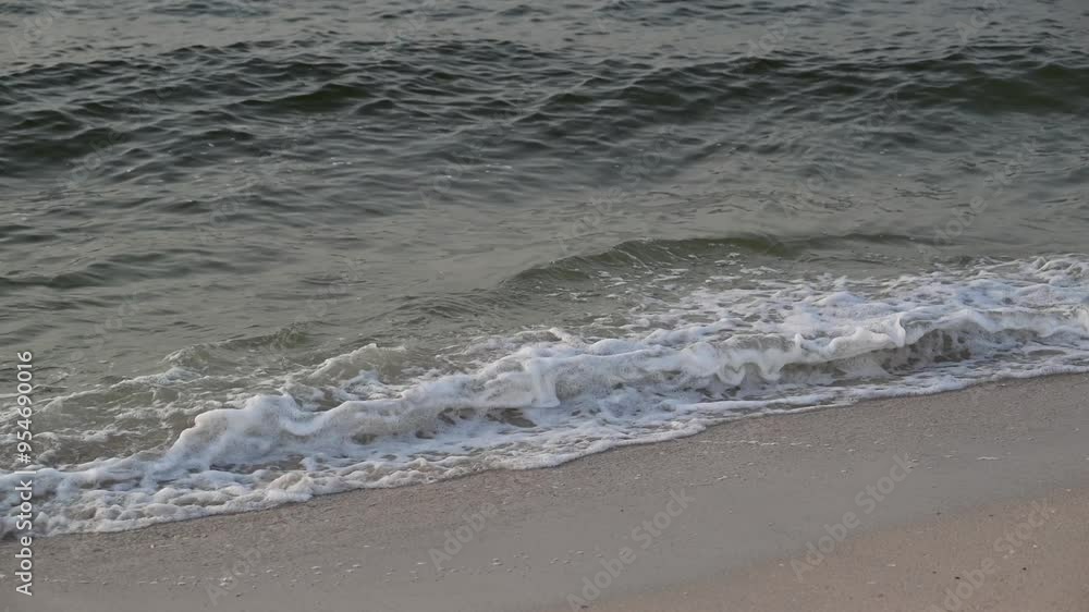 Sea waves splashing on the shore, creating foam on a beach Sea waves splashing on the shore, creating foam on a beach