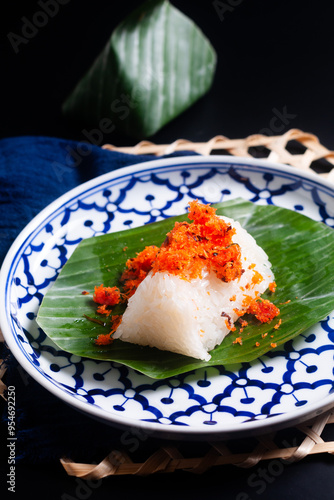 Food concept thai snack or dessert Kao Niew Na Koong  coconut Gelatinous or sticky  rice with shrimp topping on banana leave  on black background