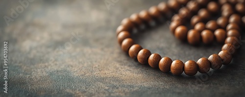 A close-up of wooden prayer beads on a textured surface, perfect for meditation, spirituality, and mindfulness concepts in photography.