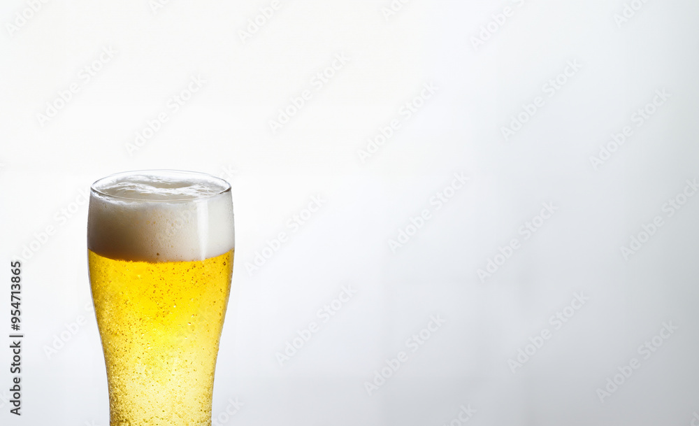 Isolated golden liquid in a glass pint with frothy white foam Isolated golden liquid in a glass pint with frothy white foam