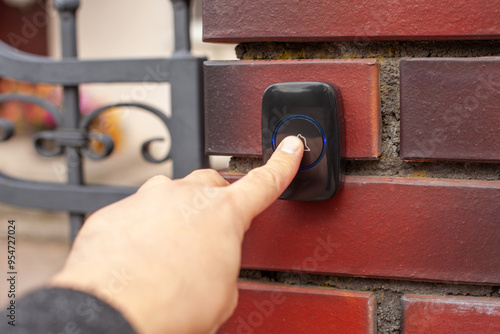 Obraz na plátne Hand Pressing Doorbell on Red Brick Wall