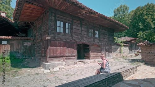 Female tourist visits pretty rural Balkan heritage village of Zheravna photo