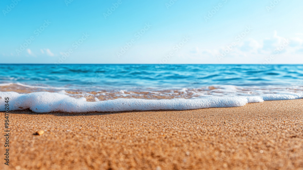A peaceful beach scene featuring gentle waves washing over golden sand under a clear blue sky, perfect for summer themes. A peaceful beach scene featuring gentle waves washing over golden sand under a clear blue sky, perfect for summer themes.