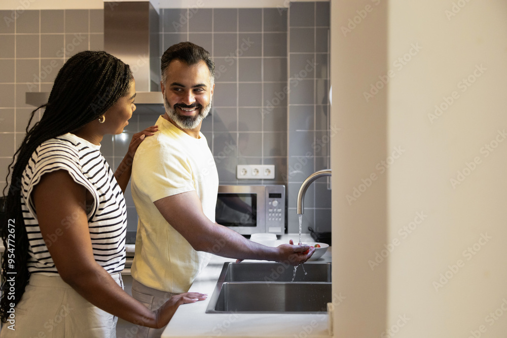 Couple enjoying a moment together in their kitchen Couple enjoying a moment together in their kitchen