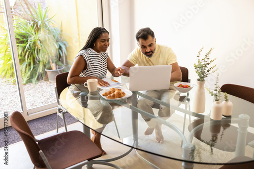 Wallpaper Mural Black woman and indian man enjoying breakfast and laptop at home Torontodigital.ca