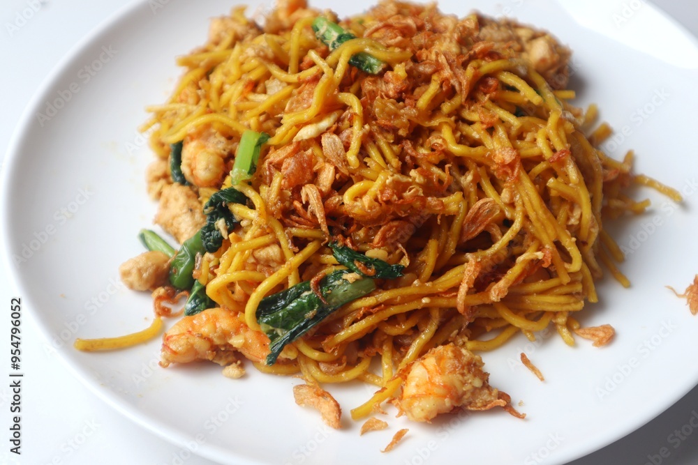 Delicious fried yellow noodles on a white plate close up view. Delicious fried yellow noodles on a white plate close up view.
