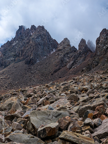 Impregnable cliffs peek out of the clouds. Stony cliffs high in the mountains. Talgar Pass photo