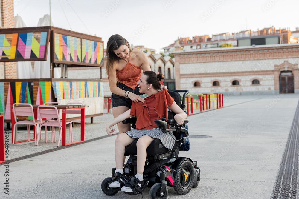 Two friends enjoying a moment together, one using a wheelchair Two friends enjoying a moment together, one using a wheelchair