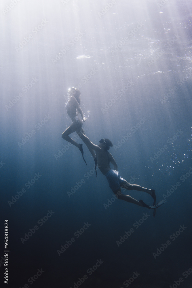 Sunlit underwater scene with two divers Sunlit underwater scene with two divers
